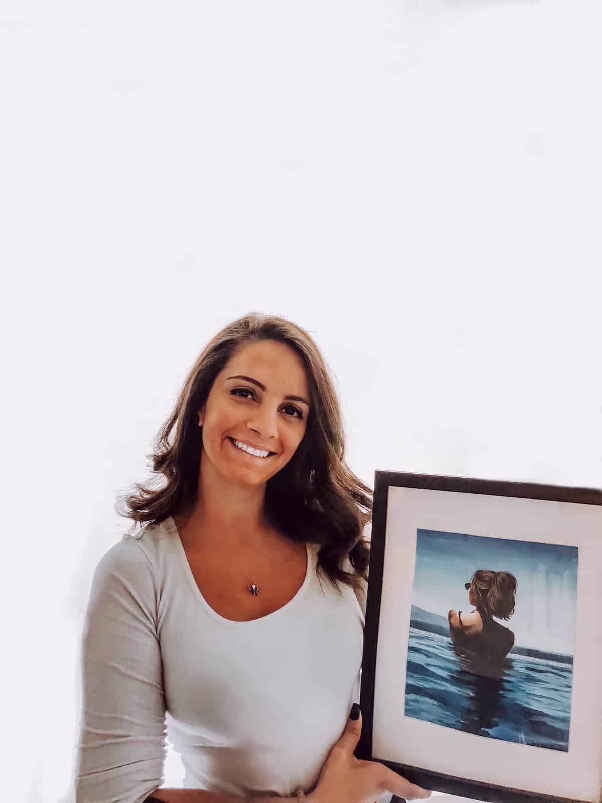 Client Holding Framed Artwork Commissioned of Herself on Vacation