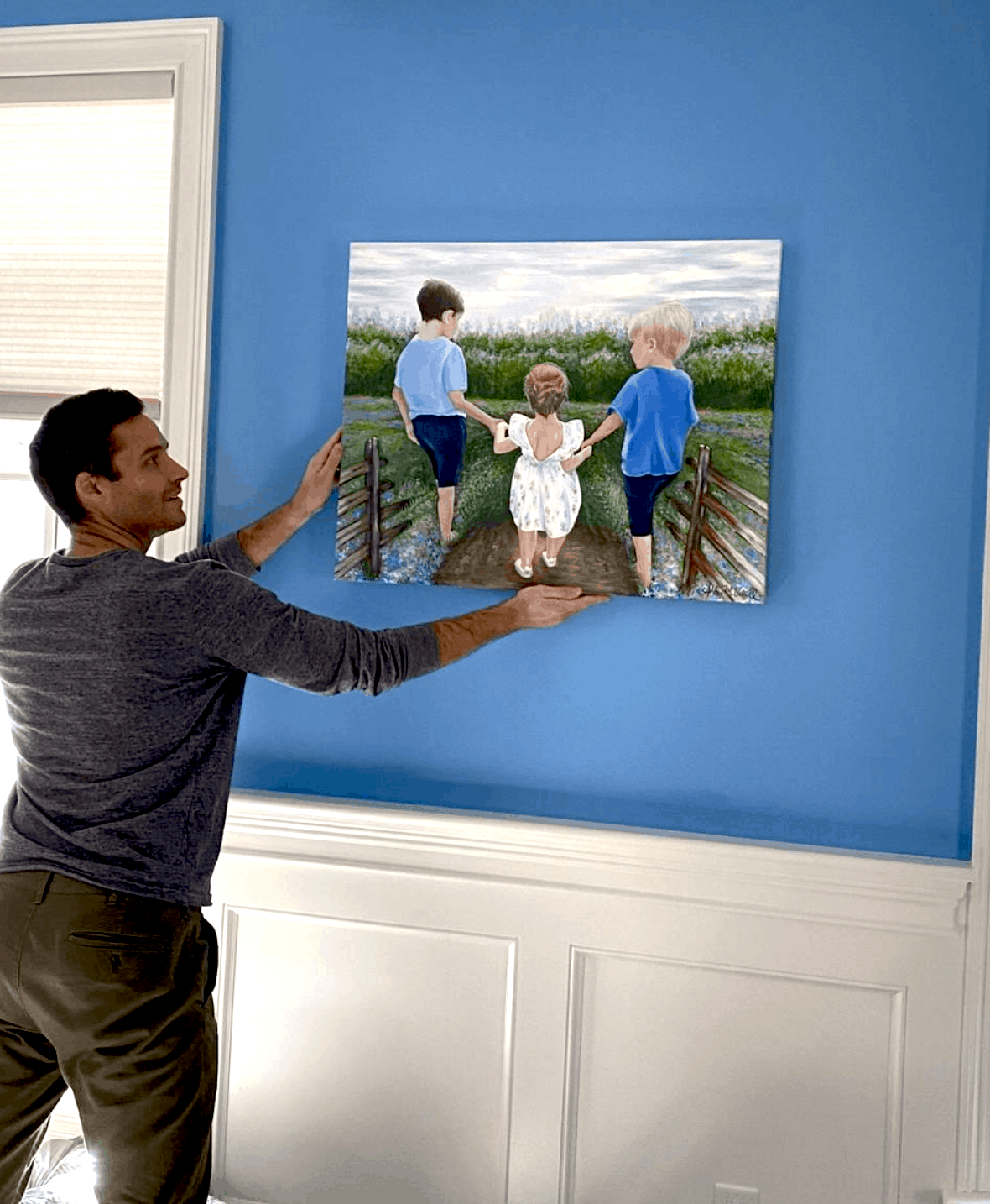 Client Hanging Custom Canvas Painted of His Children in Dining Room